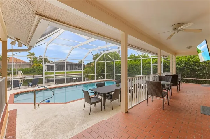View of pool with ceiling fan, a patio, and a lanai