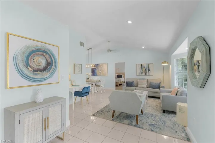 Tiled living room featuring vaulted ceiling and ceiling fan