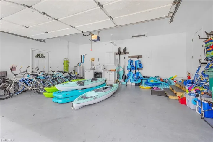 Garage with a garage door opener, ceiling fan, independent washer and dryer, and electric panel