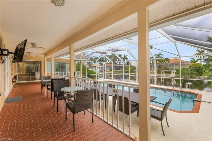 View of pool featuring ceiling fan, glass enclosure, and a patio area