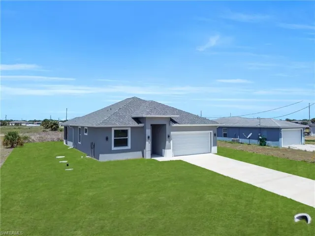 Contemporary gray stucco exterior with a gray shingle roof, attached garage, and a concrete driveway