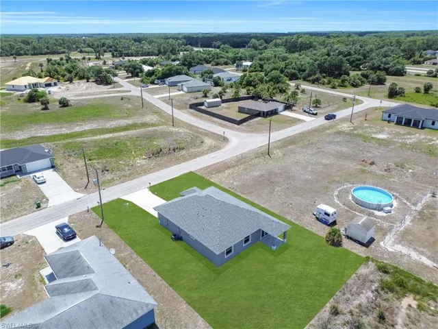 Single-story residence on an expansive lot featuring a manicured lawn and mature landscaping