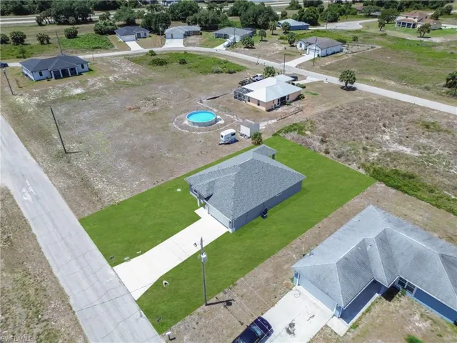 Property featuring a newly installed sod lawn, concrete driveway, and gray shingle roofing