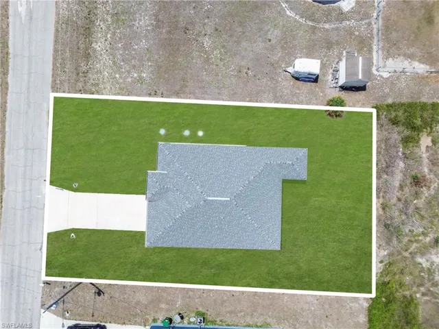 Newly constructed residence featuring a gray shingle roof, a manicured green lawn, and an extended concrete driveway
