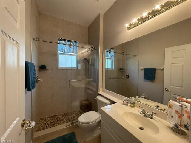 2nd bathroom with vanity and newer walk in shower and glass doors