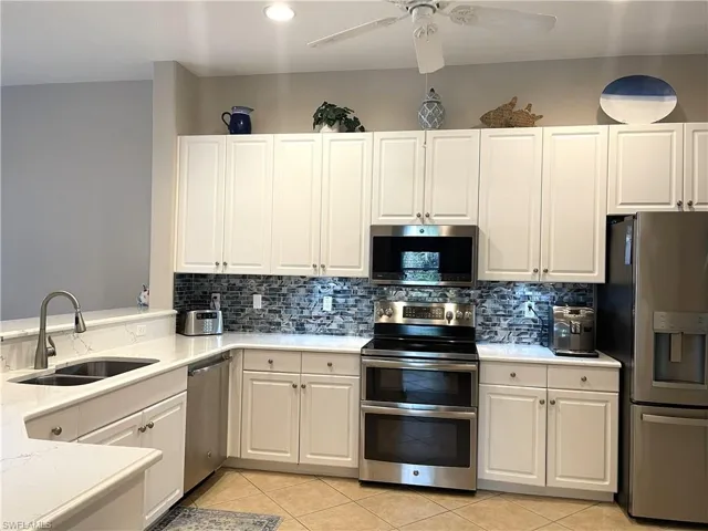 Kitchen with stainless steel appliances, stone counter tops, tile backsplash