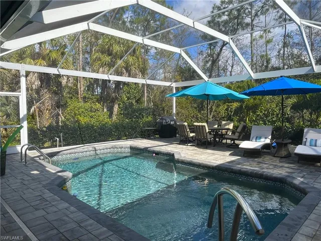 Outdoor pool with a lanai, a patio area, and outdoor dining area-Lanai was expanded an additional 10 feet and a new pool cage installed with wide view