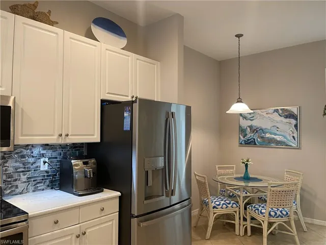 Kitchen featuring decorative backsplash, stainless steel appliances, and  another dining area