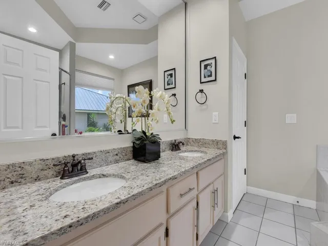 Full bath featuring a stall shower, a whirlpool tub, and tile patterned flooring