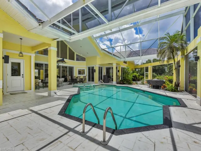 Outdoor pool with a patio area, ceiling fan, area for grilling, and glass enclosure