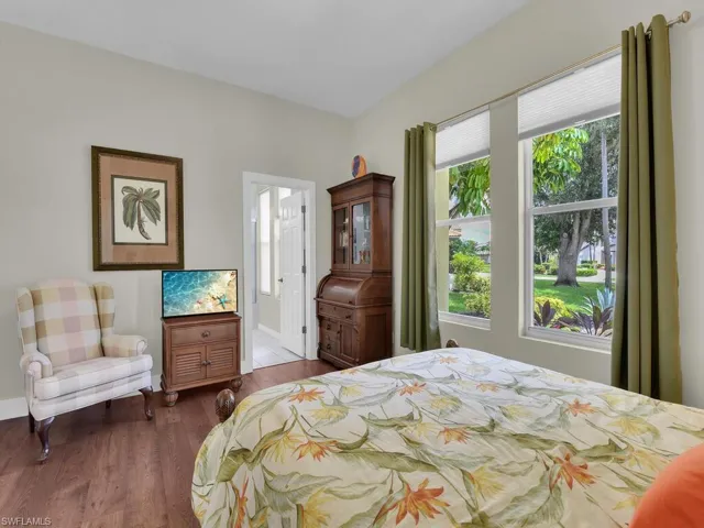 Bedroom featuring a chandelier, ensuite bathroom, and wood finished floors