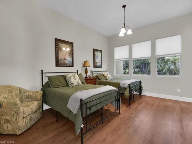 Bedroom featuring wood finished floors, a chandelier, and ensuite bathroom