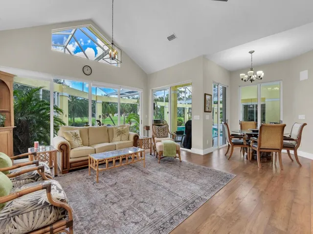 Kitchen featuring stainless steel appliances, a chandelier, a breakfast bar, white cabinetry, and dark wood-style flooring