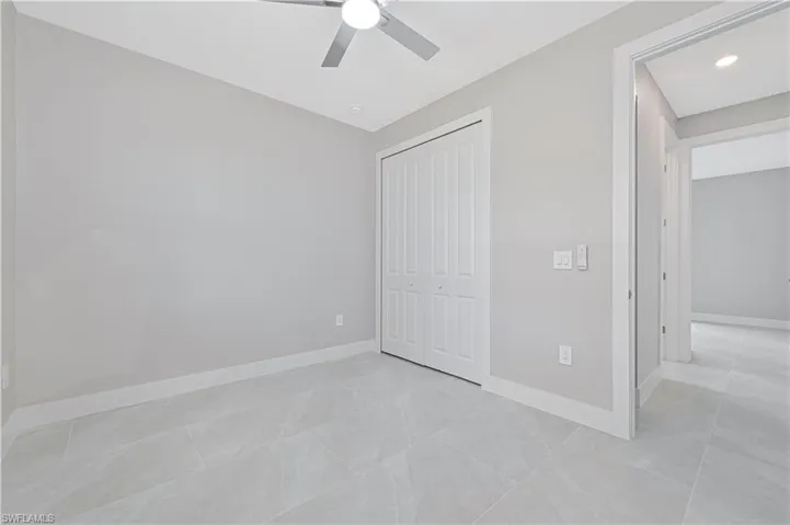 Unfurnished bedroom with a closet, ceiling fan, light tile patterned floors, and recessed lighting