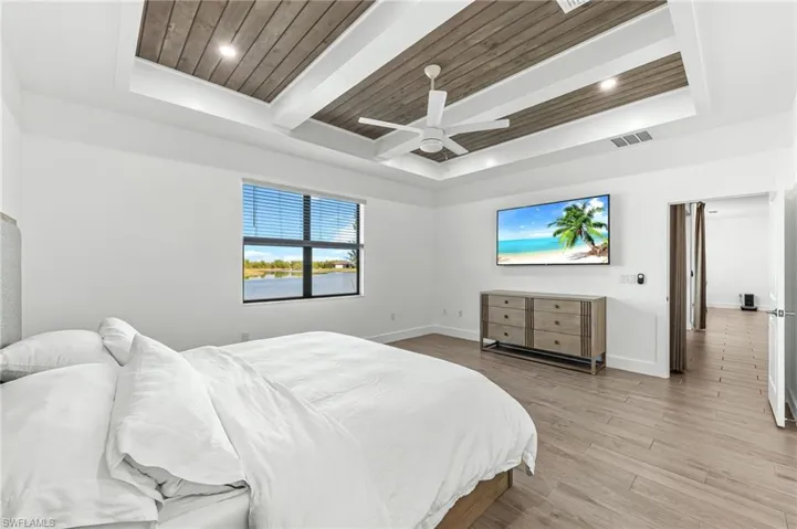 Bedroom featuring wood finished floors, a wood ceiling with exposed beams, a raised ceiling, and recessed lighting