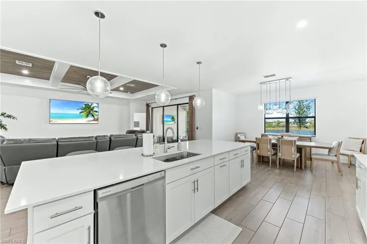 Kitchen with white cabinets, open floor plan, dishwasher, hanging light fixtures, and recessed lighting