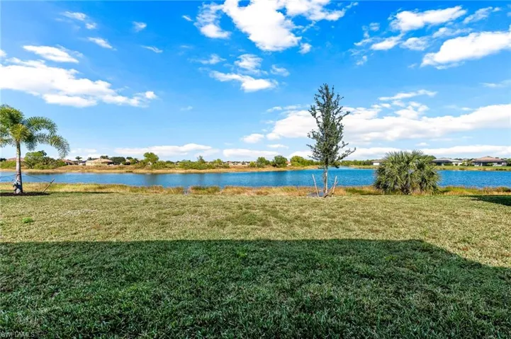 View of property's community featuring a lawn and a water view