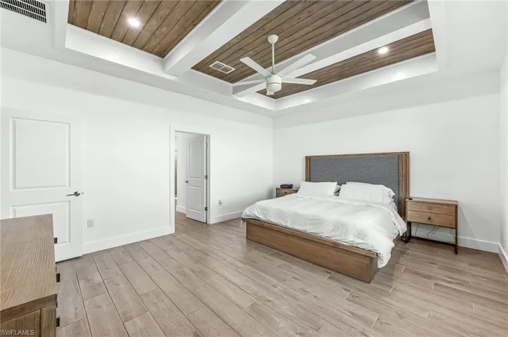 Bedroom with wood ceiling, wood finish floors, recessed lighting, a ceiling fan, and a raised ceiling