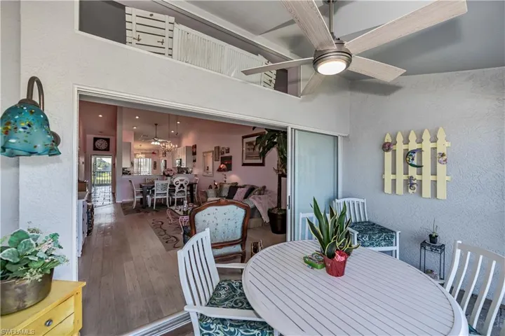 Dining area with hardwood / wood-style flooring and ceiling fan with notable chandelier