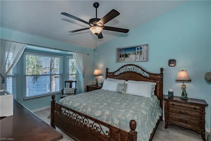 Bedroom featuring light hardwood / wood-style floors, lofted ceiling, and ceiling fan