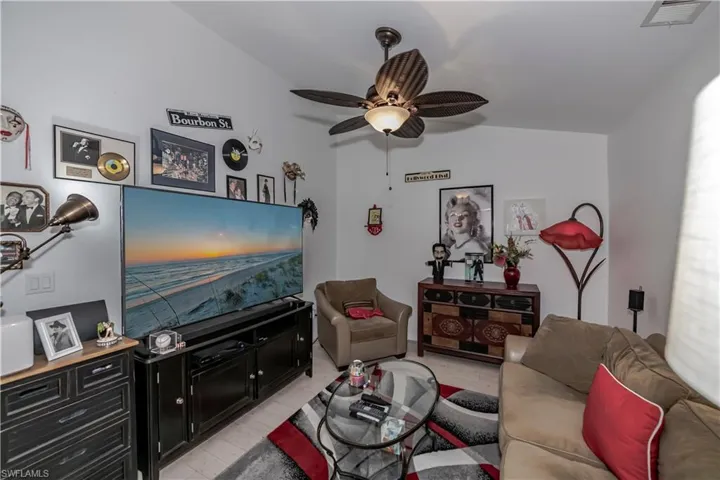 Living room featuring ceiling fan, light hardwood / wood-style floors, and lofted ceiling