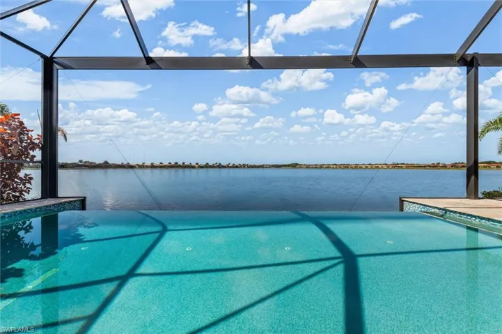 Infinity-edge pool with turquoise tile, overlooking a broad expanse of water