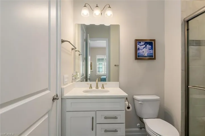 Bathroom vanity featuring a quartz countertop, an undermount sink, and a gold-tone faucet