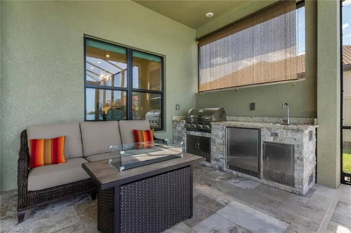 Outdoor patio featuring a built-in grill, integrated sink, and stainless steel appliances