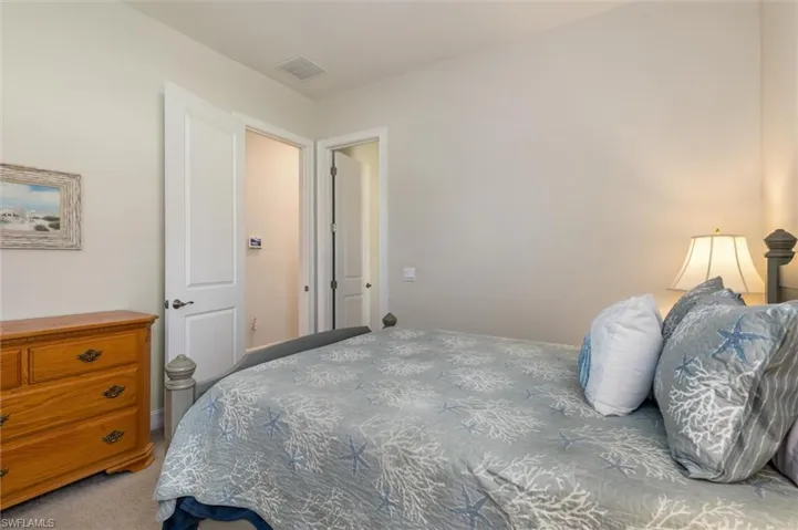 Guest Bedroom 2 Neutral-toned walls complement plush carpeting