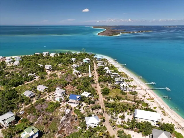 Birds eye view of property featuring a beach view and a water view