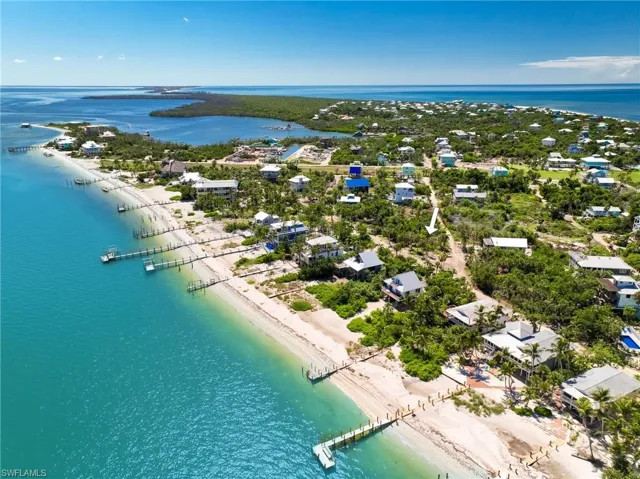 Birds eye view of property featuring a beach view and a water view