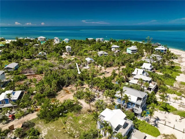 Birds eye view of property with a beach view and a water view
