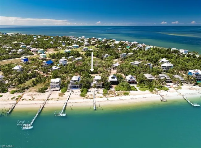 Birds eye view of property with a water view and a view of the beach