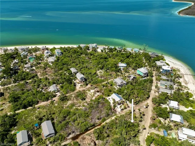 Birds eye view of property featuring a water view and a beach view