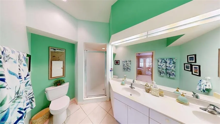 Full bath featuring a stall shower, double vanity, light tile patterned floors, and recessed lighting