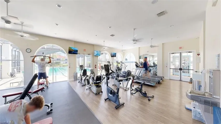 Workout area featuring a ceiling fan and french doors