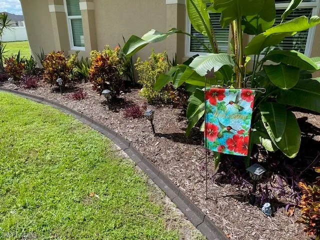 Landscape curbing and tropical plantings at entrance welcomes you!