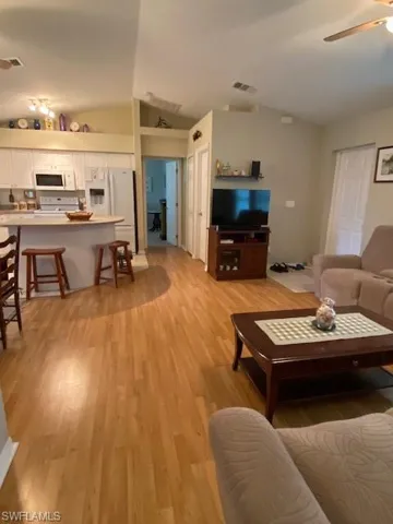 Great room with view towards kitchen and hallway leading to main bedroom