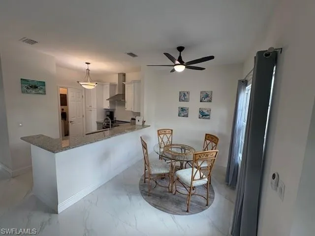 Dining area featuring light marble finish flooring and ceiling fan