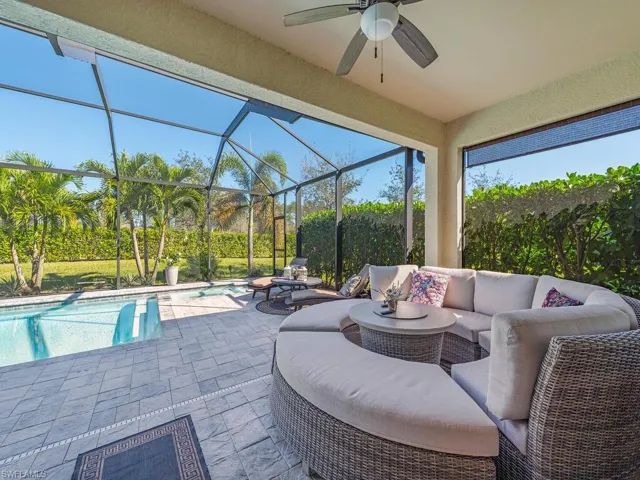 View of patio featuring a ceiling fan, glass enclosure, an outdoor pool, and an outdoor hangout area