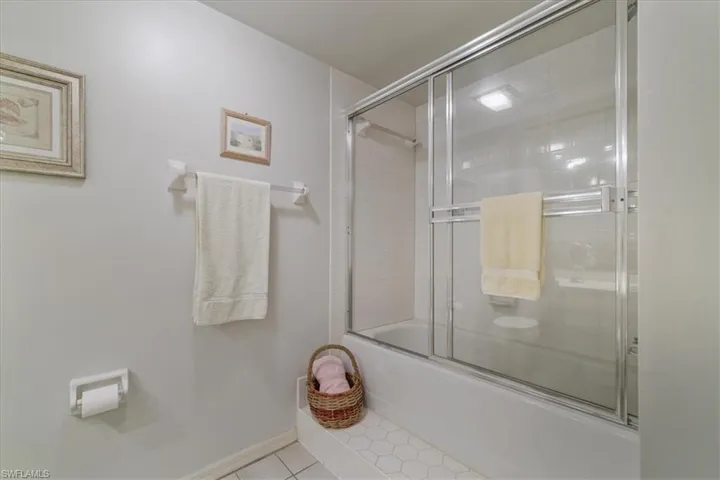 Full bathroom featuring combined bath / shower with glass door and tile patterned floors