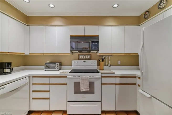 Kitchen featuring white cabinetry, white appliances, light countertops, crown molding, and recessed lighting