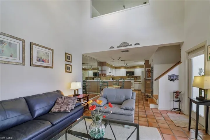 Tiled living room featuring a high ceiling