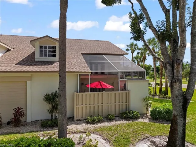 Back of property featuring a sunroom, a shingled roof, stucco siding, and a lanai