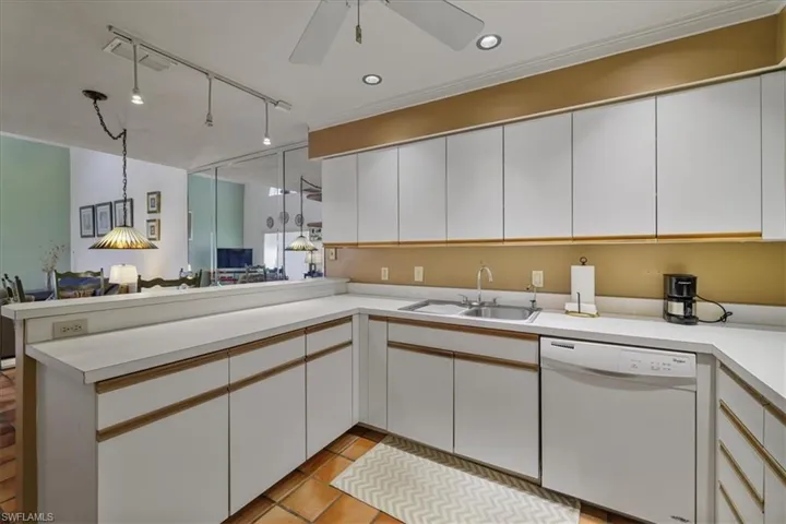 Kitchen featuring white cabinets, open floor plan, white dishwasher, light countertops, and recessed lighting