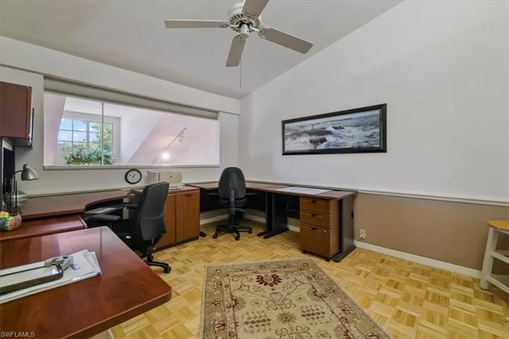 Office space with lofted ceiling and a ceiling fan