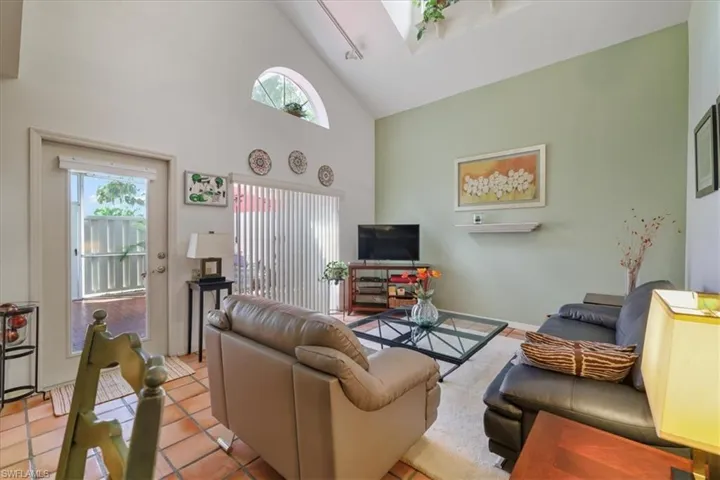 Tiled living room with high vaulted ceiling and a skylight