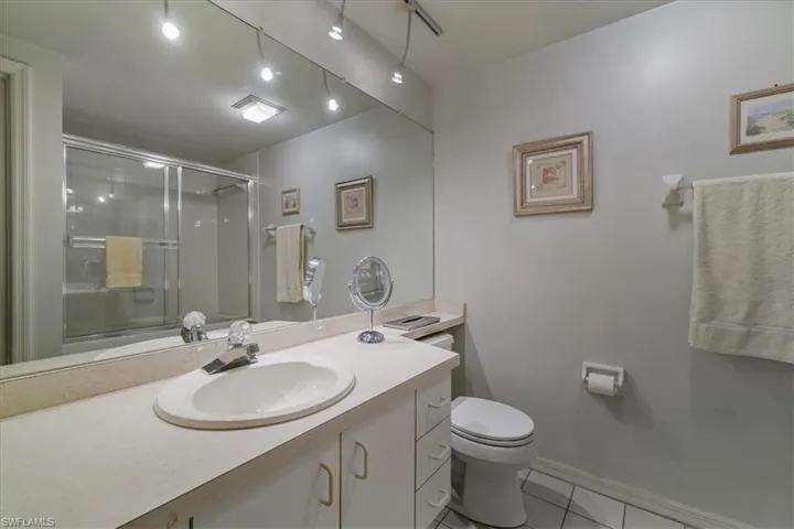 Bathroom featuring light tile patterned flooring, vanity, and a stall shower