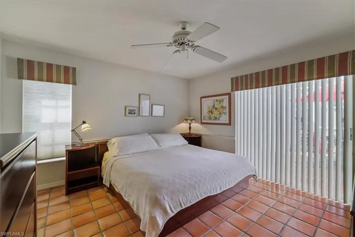Bedroom featuring multiple windows, light tile patterned floors, and a ceiling fan