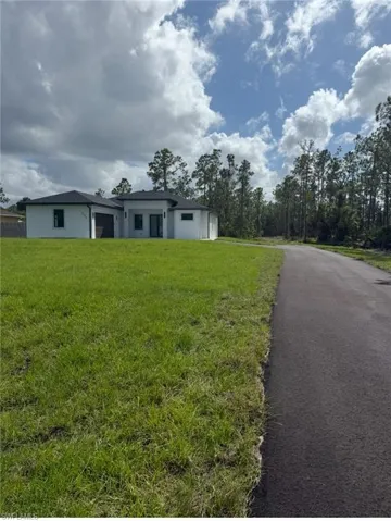 View of front of property with stucco siding and a front yard